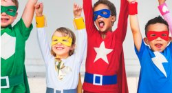 Image of four children in superhero costumes